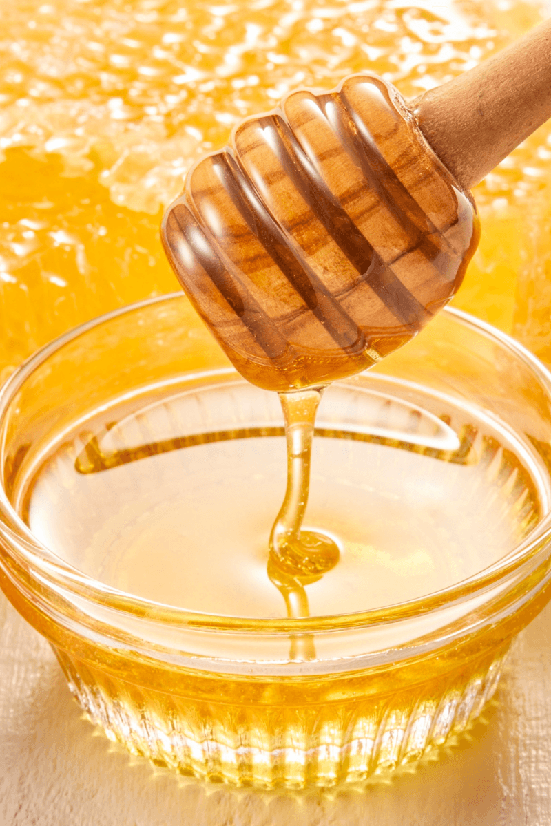 Honey benefits for facehoney dipper dripping into bowl – highlighting benefits of honey for skin | skincaresolutions.in