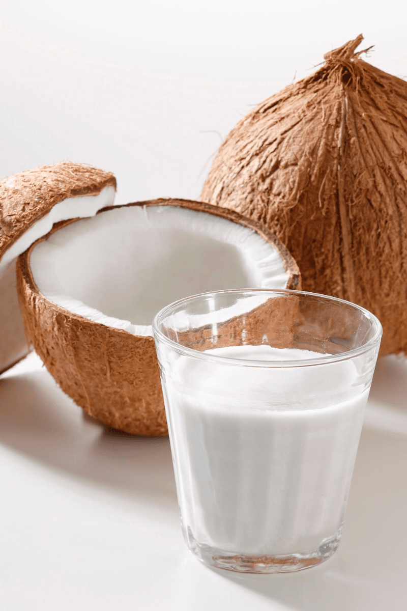 Fresh coconut half with creamy white coconut milk or cream in a small bowl – deeply nourishing DIY winter moisturizer | skincaresolutions.in