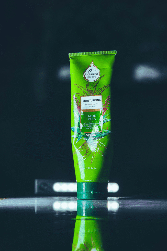 Store-bought aloe vera gel in a clear green bottle on bathroom shelf | skincaresolutions.in